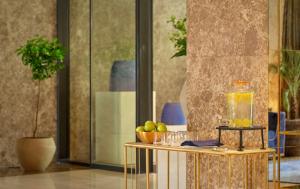 a table with glasses and a bowl of fruit on it at Grand Hotel Brioni Pula, A Radisson Collection Hotel in Pula