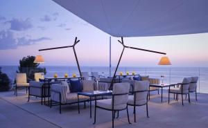a patio with tables and chairs with a view of the ocean at Grand Hotel Brioni Pula, A Radisson Collection Hotel in Pula