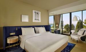 a bedroom with a large bed and a large window at Grand Hotel Brioni Pula, A Radisson Collection Hotel in Pula
