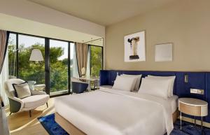 a bedroom with a large white bed and a chair at Grand Hotel Brioni Pula, A Radisson Collection Hotel in Pula