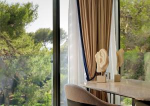 a room with a window with a table and a chair at Grand Hotel Brioni Pula, A Radisson Collection Hotel in Pula