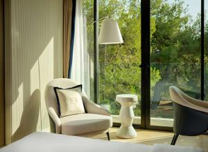 a bedroom with a bed and two chairs and a window at Grand Hotel Brioni Pula, A Radisson Collection Hotel in Pula