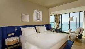 a bedroom with a large white bed with a view of the ocean at Grand Hotel Brioni Pula, A Radisson Collection Hotel in Pula
