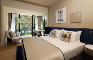 a bedroom with a large white bed and a chair at Grand Hotel Brioni Pula, A Radisson Collection Hotel in Pula