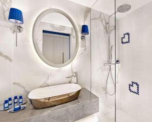a bathroom with a round mirror and a tub at Grand Hotel Brioni Pula, A Radisson Collection Hotel in Pula