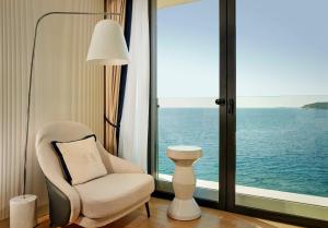 a living room with a chair and a large window at Grand Hotel Brioni Pula, A Radisson Collection Hotel in Pula