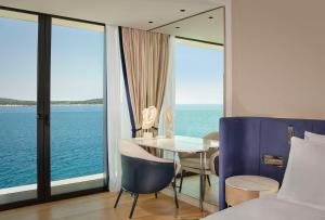 a bedroom with a table and a view of the ocean at Grand Hotel Brioni Pula, A Radisson Collection Hotel in Pula