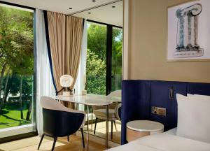 a room with a table and chairs and a bed at Grand Hotel Brioni Pula, A Radisson Collection Hotel in Pula