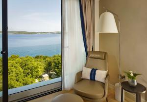 a room with a chair and a large window at Grand Hotel Brioni Pula, A Radisson Collection Hotel in Pula