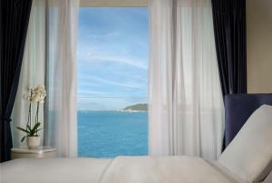 a bedroom with a window with a view of the ocean at Grand Hotel Brioni Pula, A Radisson Collection Hotel in Pula