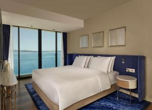 a large white bed in a room with a large window at Grand Hotel Brioni Pula, A Radisson Collection Hotel in Pula