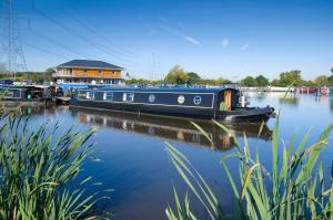 a blue boat is docked on the water at Cosy & Chic in great location near Loughborough Uni & East Midlands Airport in Loughborough