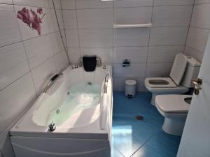 a small bathroom with a tub and a toilet at Manga Luxury Apartments - 2 Bedrooms in Gjirokastër +7 photos