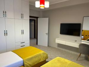 - une chambre avec un lit et une télévision à écran plat dans l'établissement Manga Apartments 3+1, à Gjirokastër