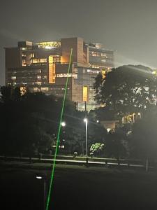 a green laser beam in front of a building at night at Yb home in Sonīpat