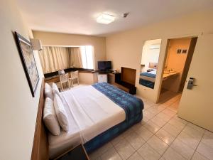 Habitación de hotel con cama y baño en Hotel Euro Suíte Recife Boa Viagem, en Recife