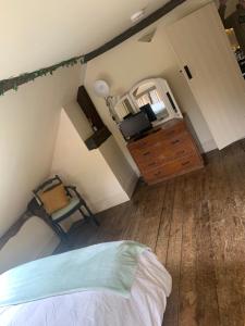 1 dormitorio con 1 cama, vestidor y silla en Becs, en Leominster