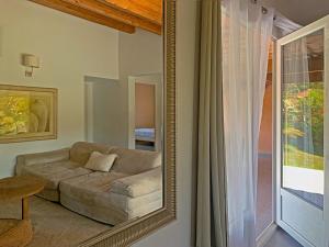 a living room with a couch and a mirror at Résidence Maora Village in Bonifacio +50 photos