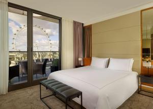 a bedroom with a large white bed and a large window at Park Plaza County Hall London in London