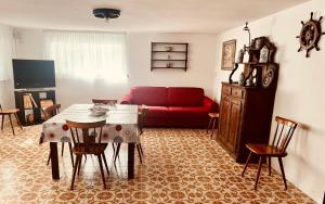 - un salon avec un canapé rouge et une table dans l'établissement Spacious House Venice Lido near ferry and the sea, sur le Lido de Venise