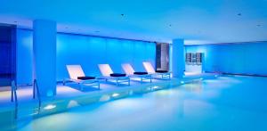 a swimming pool in a building with blue lighting at Park Plaza London Waterloo in London