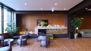 a lobby with tables and chairs and a bar at Dormy Inn Aomori Natural Hot Spring in Aomori