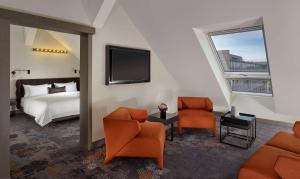 Habitación de hotel con 1 cama, 2 sillas y TV. en Park Plaza Nuremberg, en Núremberg