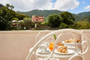 - une table avec un plateau de croissants et une tasse de jus d'orange dans l'établissement Villapiana Country House, à Pellezzano