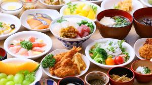 a table topped with bowls of different types of food at Dormy Inn Aomori Natural Hot Spring in Aomori