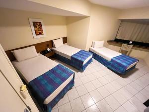 a hotel room with two beds and a television at Hotel Euro Suíte Recife Boa Viagem in Recife