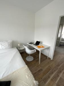 a bedroom with a bed and a desk with a laptop at Appartement Design X - Hyper Centre - Parking Privé - Quimper in Quimper