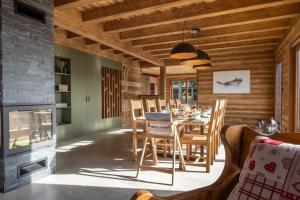 a dining room with a table and a fireplace at Chalet La Tribu du Danay, neuf, 12 personnes in Saint-Jean-de-Sixt