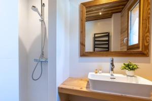 a bathroom with a sink and a mirror at Chalet La Tribu du Danay, neuf, 12 personnes in Saint-Jean-de-Sixt +24 photos