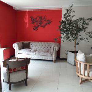 sala de estar con sofá y pared roja en DAKAR HOTEL en Mendoza