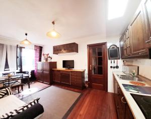 kuchnia z drewnianymi szafkami i salon w obiekcie CASTRO COSTA NORTE Apartamento Jardín Garaje w mieście Castro-Urdiales