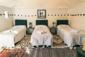 Ένα ή περισσότερα κρεβάτια σε δωμάτιο στο Merzouga Prestige Camp