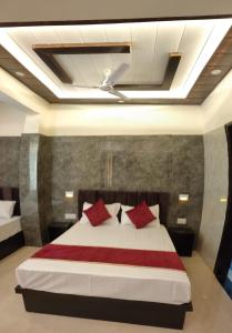 a bedroom with a large bed with red pillows at Hotel Goyal Palace in Agra