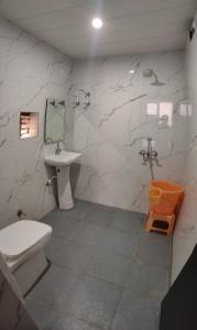 a bathroom with a toilet and a sink at Hotel Goyal Palace in Agra