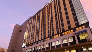 a tall building with windows on the side of it at Dormy Inn Aomori Natural Hot Spring in Aomori