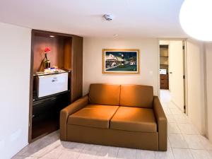 a living room with a couch and a television at Hotel Euro Suíte Recife Boa Viagem By Nacional Inn in Recife