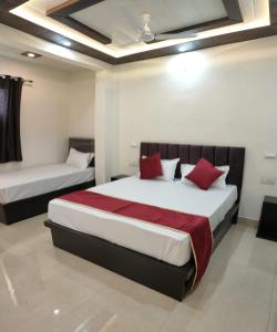 1 dormitorio con 2 camas y almohadas rojas en Hotel Goyal Palace, en Agra