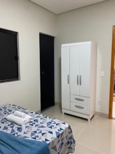 um quarto com uma cama e um armário branco em Flat Dona D - Prox da JK em Palmas