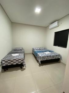 a room with two beds and a flat screen tv at Flat 03 - Prox da JK - Delior 2 in Palmas