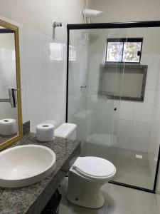 a bathroom with a toilet and a sink and a shower at Flat Dona D - Prox da JK in Palmas