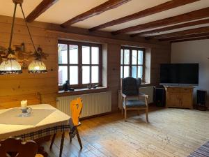 een woonkamer met een televisie en een tafel en stoelen bij Ferienwohnung Rumpf**** in Volkmarsen