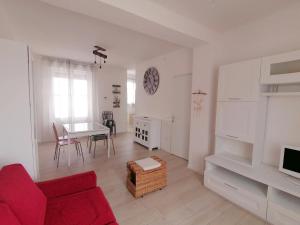 阿奎萊亞的住宿－Casa Magnolia，客厅配有红色的沙发和桌子