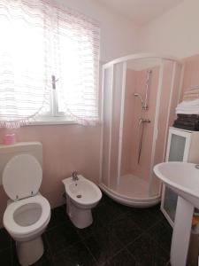 een badkamer met een toilet, een douche en een wastafel bij Casa Magnolia in Aquiléia
