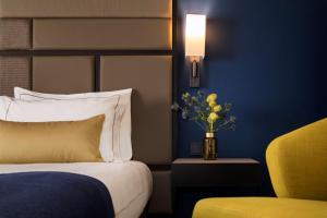 a hotel room with a bed and a vase of flowers at Park Plaza Utrecht in Utrecht