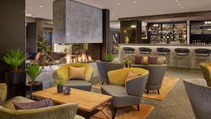 a bar with chairs and tables and a fireplace at Park Plaza Utrecht in Utrecht