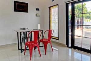a dining room with red chairs and a table at OYO 92945 Guest House Nusa Indah Syariah in Bandar Lampung